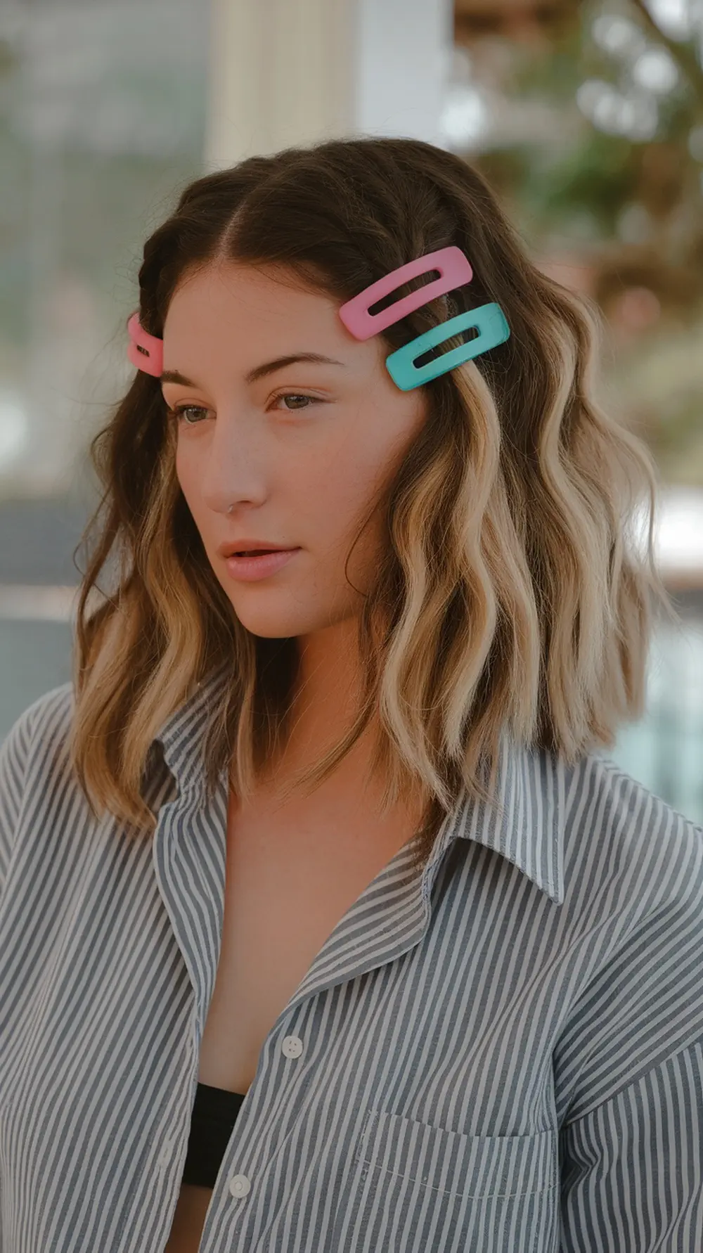 A woman with beach waves hairstyle adorned with colorful hair clips.