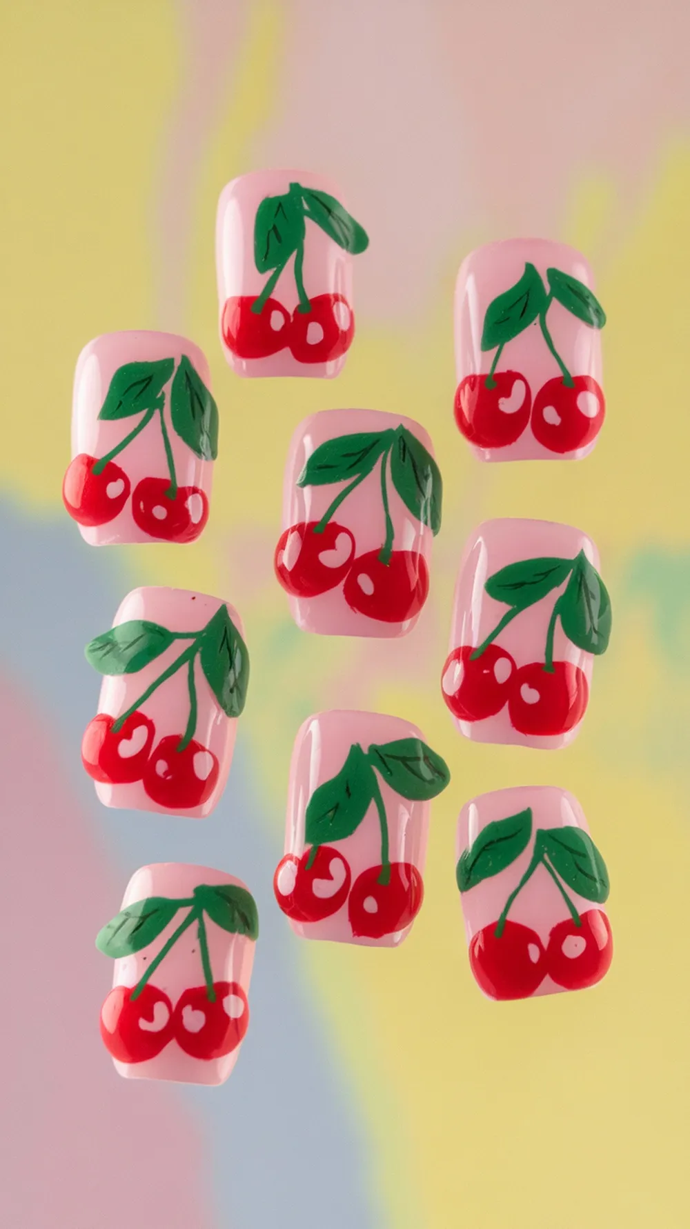 Nails with cherry designs on a pink background